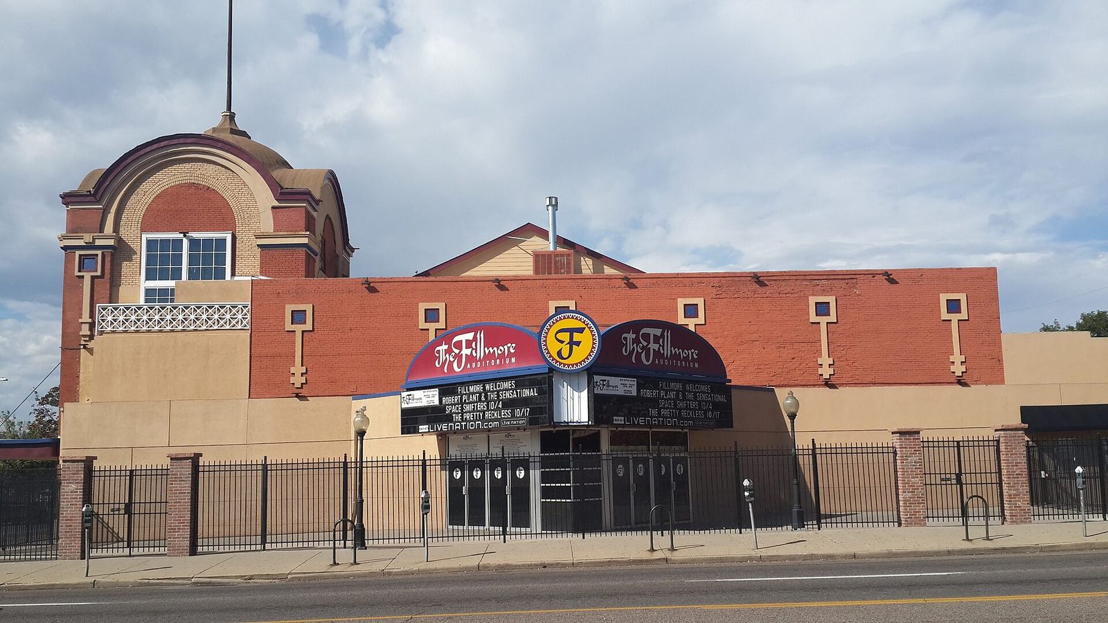 The red brick and cream facade of the Fillmore Auditorium on Colfax Avenue in Denver, with its double marquee listing upcoming shows above the entrance doors
