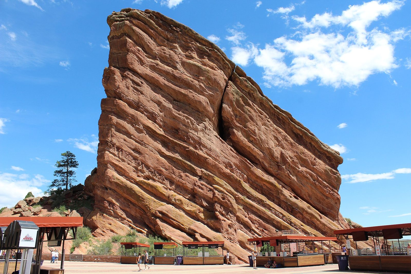 The huge tilted sandstone fin of Ship Rock rising above the concession stands on the upper plaza at Red Rocks Amphitheatre under a blue sky